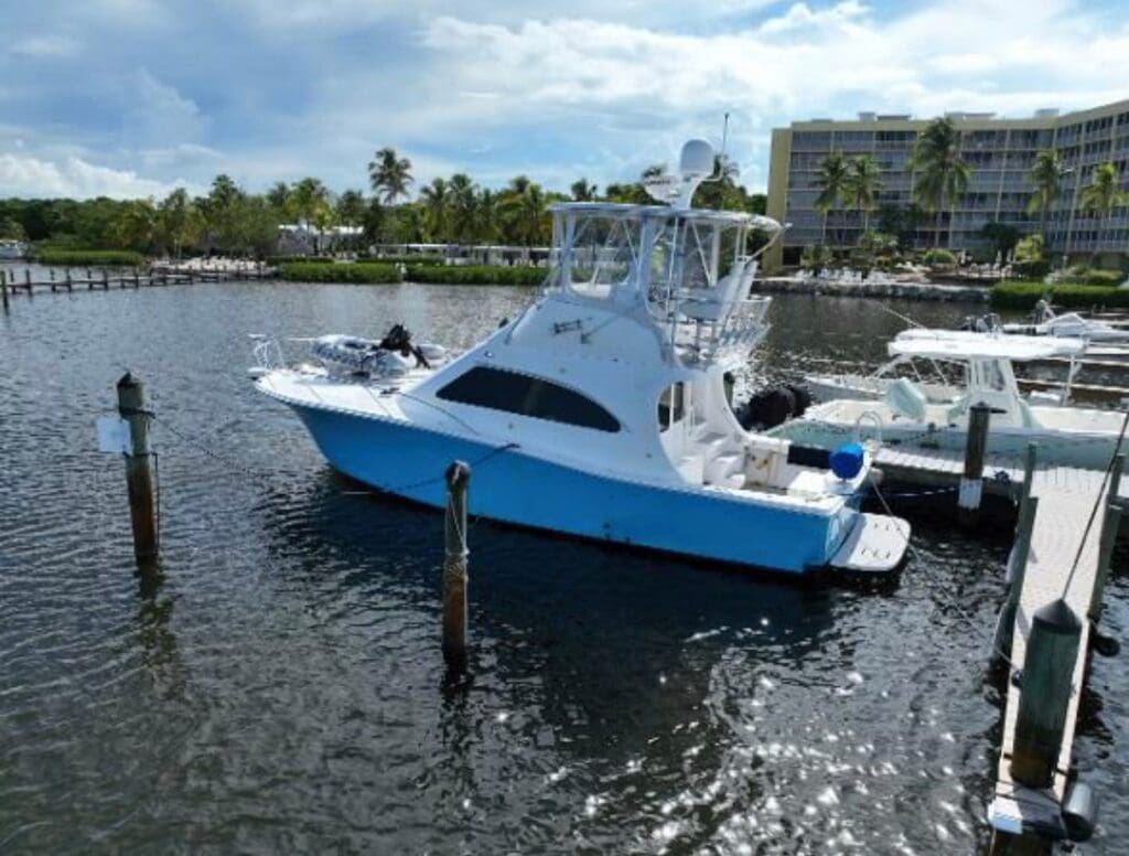 A boat is docked in the water near some boats.